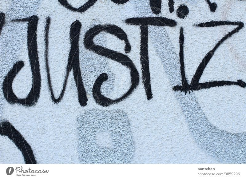 Justiz steht auf einer Mauer. Graffiti in schwarz Justizgewalt Gesetze und Verordnungen Justitia Anwalt Gefängnis Verbrechen Urteil Wort Gericht gesetzt