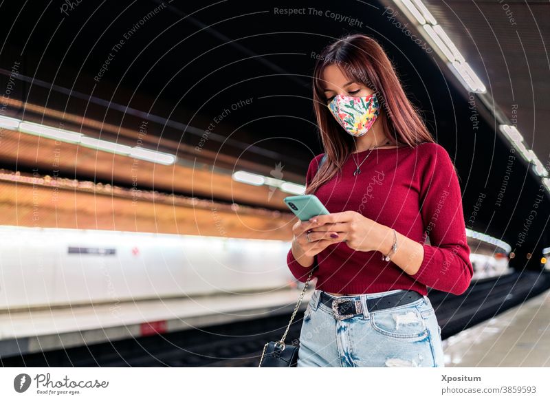 Junge Frau benutzt Smartphone am Bahnhof Porträt Maske Gesicht Mundschutz Lifestyle Podest modern Öffentlich Station Technik & Technologie Verkehr Kaukasier