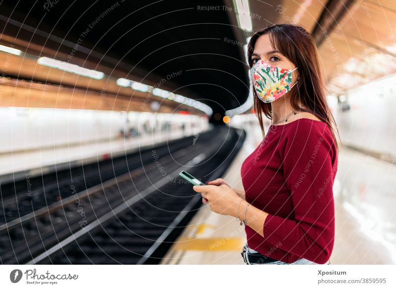 Junge Frau benutzt Smartphone am Bahnhof Porträt Maske Gesicht Mundschutz Lifestyle Podest modern Öffentlich Station Technik & Technologie Verkehr Kaukasier