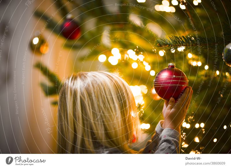 Kind hält voller ehrfurcht eine Christbaumkugel in den Händen Weihnachten & Advent Ehrfurcht ehrfürchtig niedlich Vorfreude Weihnachtsbaum Lichterkette leuchten