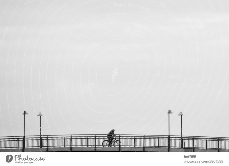 Fahrrad fahren auf einer Brücke - die Laternen rahmen das Geschehen kunstvoll ein Fahrradfahren Mensch Minimalismus Lifestyle Erwachsene Silhouette Bewegung
