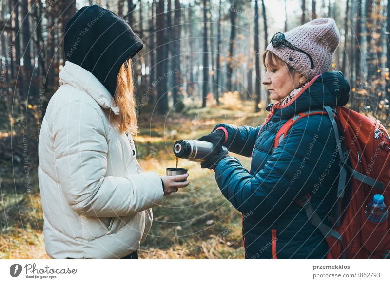 Mutter und Tochter mit Rucksack haben Pause während der Herbstreise an einem kalten Herbsttag aktiv Aktivität Abenteuer Backpacker Kaffee Tasse Ausflugsziel