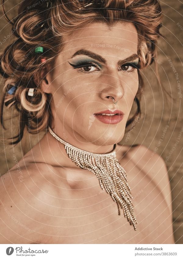 Dragqueen mit Halskette schaut in die Kamera Mann Transgender Make-up elegant Vorschein androgyn Frisur Reichtum Porträt ohne Hemd männlich jung Model Glamour