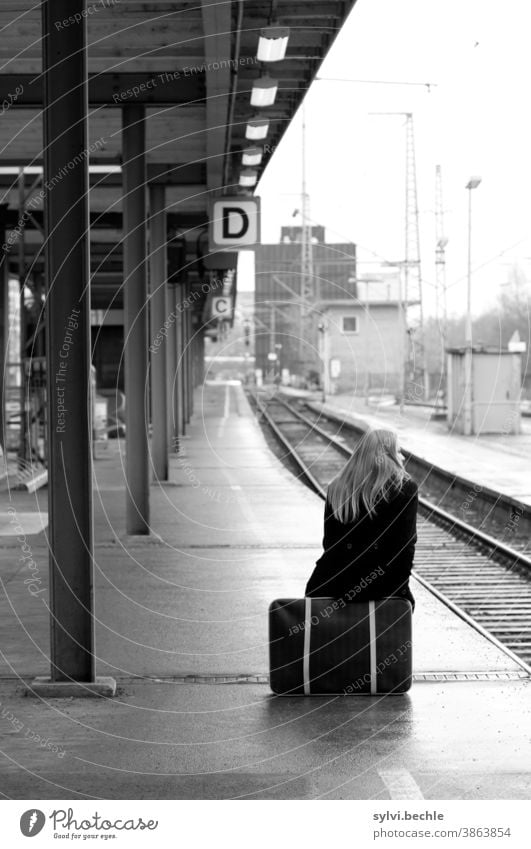 Irgendwie wird es weitergehen ... Eisenbahngleis Bahnhof Podest Zug Frau sitzen Koffer gepackt warten Abwarten wegfahren Urlaub Fernweh Heimweh Reise