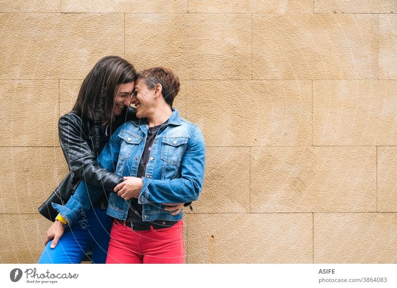 Glückliches lesbisches Paar mittleren Alters umarmt sich im Freien lgbtq schwul mittleres Alter 40 50 umarmend Beteiligung Umarmen Lachen Lächeln Nase