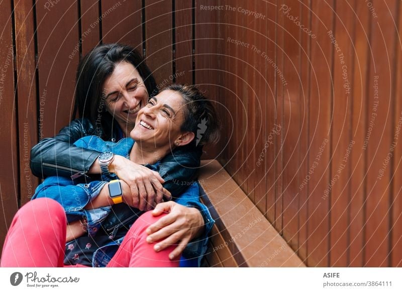 Glückliche Momente in einem lesbischen Paar mittleren Alters lgbtq schwul mittleres Alter 40 50 umarmend Beteiligung Umarmen Lachen Lächeln Homosexualität