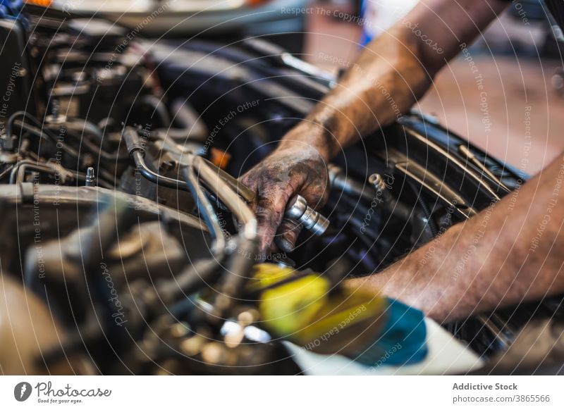 Crop-Techniker mit Taschenlampe bei der Untersuchung eines Automotors Mann Mechaniker prüfen Motor PKW Garage leuchten Arbeit Reparatur männlich Fahrzeug
