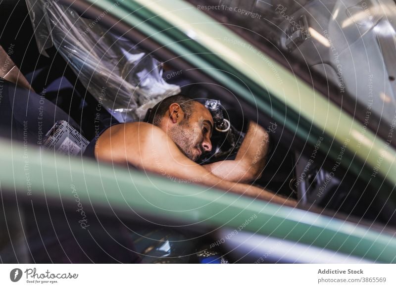 Männlicher Techniker, der das Armaturenbrett eines Autos überprüft Mann prüfen PKW Garage Arbeit Sitz modern Dienst männlich Erwachsener Lügen Passagier