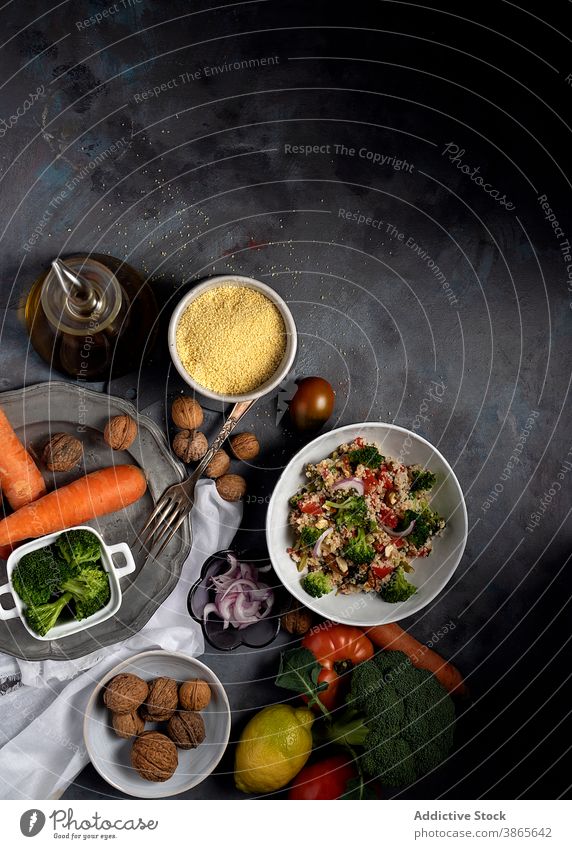 Vegetarischer Couscoussalat auf dem Tisch mit Zutaten Salatbeilage Gemüse Vegetarier bulgur tabbouleh Gesundheit Bestandteil Lebensmittel Schalen & Schüsseln