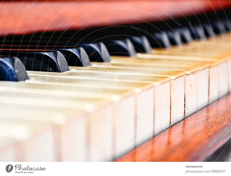 Nahaufnahme der Tasten eines alten abgenutzten Klaviers. Keyboard Instrument Musical Detailaufnahme Schwarzer Schlüssel Holz Elfenbein Antiquität