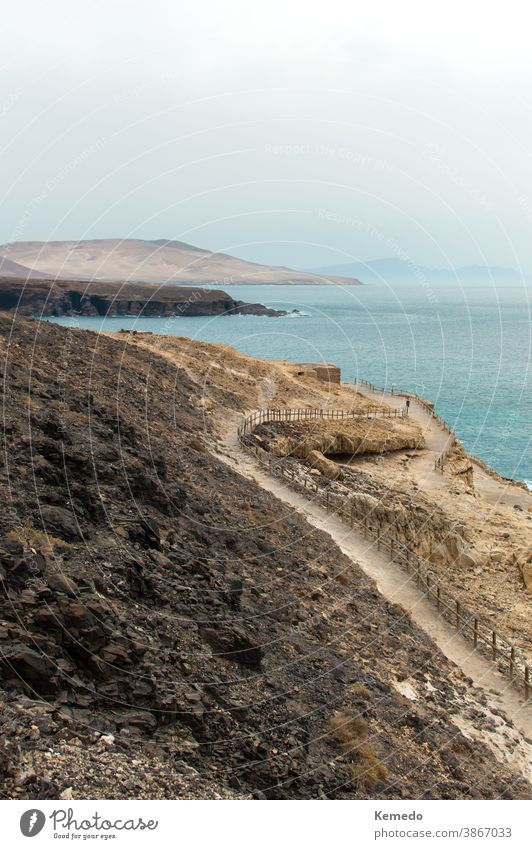 Landschaft eines Weges zwischen den Bergen und dem Ozean in Ajuy, Fuerteventura (Kanarische Inseln), Spanien. Meer Berge u. Gebirge MEER ajuy Spanisch Nachlauf