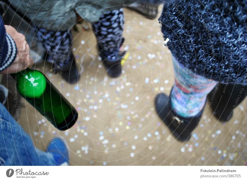 Glasflasche und tanzende Menschen stehen darußen auf einem Boden voller Konfetti trinken Erfrischungsgetränk Alkohol Bier Freude Party Musik Bar Cocktailbar