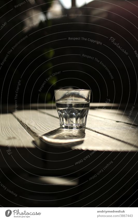 Klares Wasser in einem klaren Glas gegen. Gesundes Essen und umweltfreundliches natürliches Wasser. ein Glas Wasser auf einem Holztisch. trinken Gesundheit