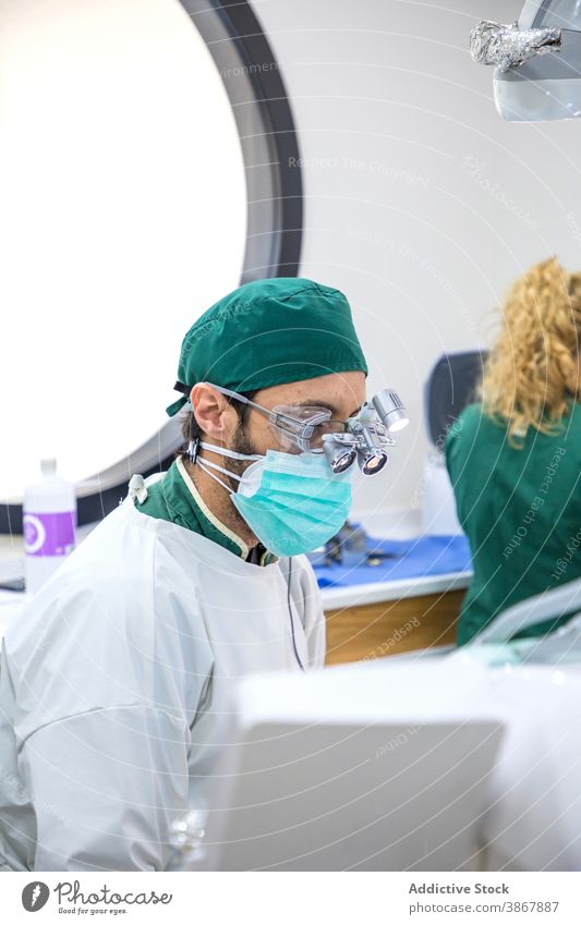Männlicher Zahnarzt in medizinischer Maske und Brille in der Klinik dental mündlich Leckerbissen Mann Arzt Fernglas Stomatologie Zahnmedizin professionell