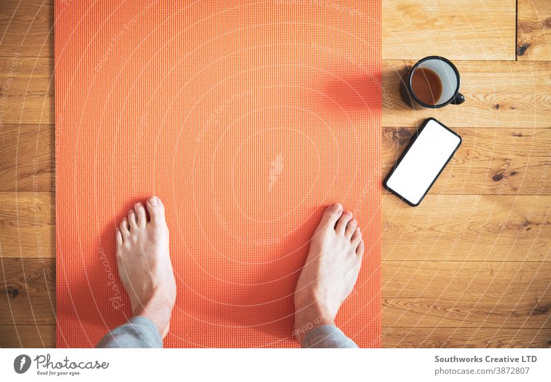 Auf Yogamatte stehender Mann mit Kaffee und Mobiltelefon. Anschluss Technik & Technologie Anruf Telefon Funktelefon klug Barfuß Smartphone Zelle Touchscreen