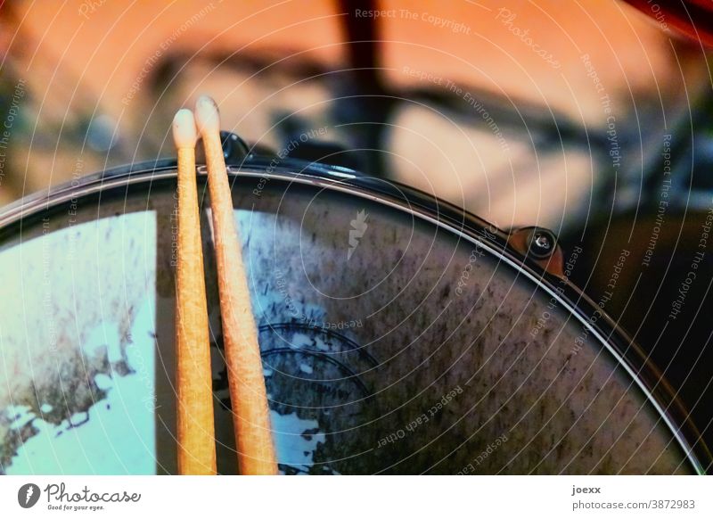 Drumsticks liegen auf Snaredrum mit stark abgenutztem Fell, schwache Tiefenschärfe Sticks Schlagzeug spielen Pause kleine Trommel Holzsticks Trommelfell
