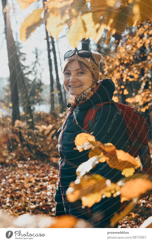 Frau mit Rucksack wandert an einem sonnigen Herbsttag in einem Wald aktiv Aktivität Abenteuer Backpacker Ausflugsziel genießen Erkundung erkunden fallen