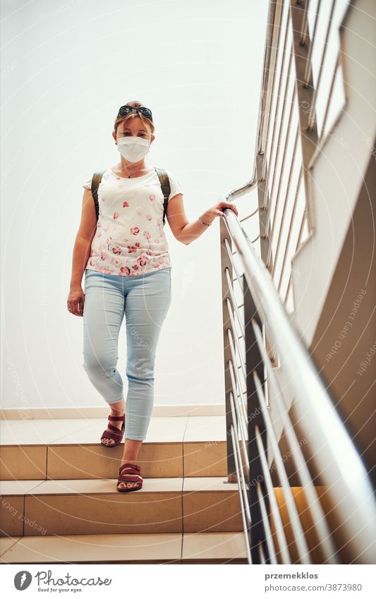 Frau geht mit Gesichtsmaske nach unten, um Mund und Nase während des Ausbruchs des pandemischen Coronavirus zu bedecken Apotheke Mundschutz covid-19 Pandemie