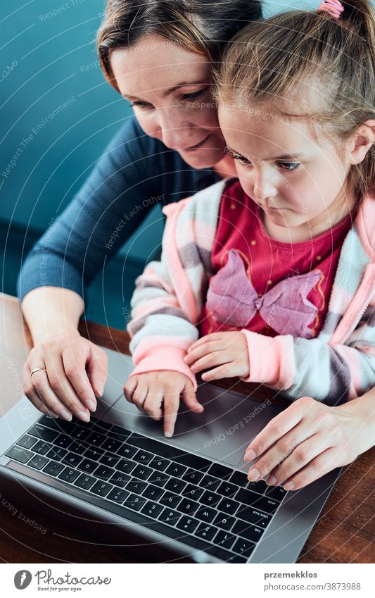 Kleines Mädchen im Vorschulalter lernt online Puzzles zu lösen, indem es zu Hause auf dem Laptop Lernspiele spielt Aufmerksamkeit Kaukasier Kind Kindheit