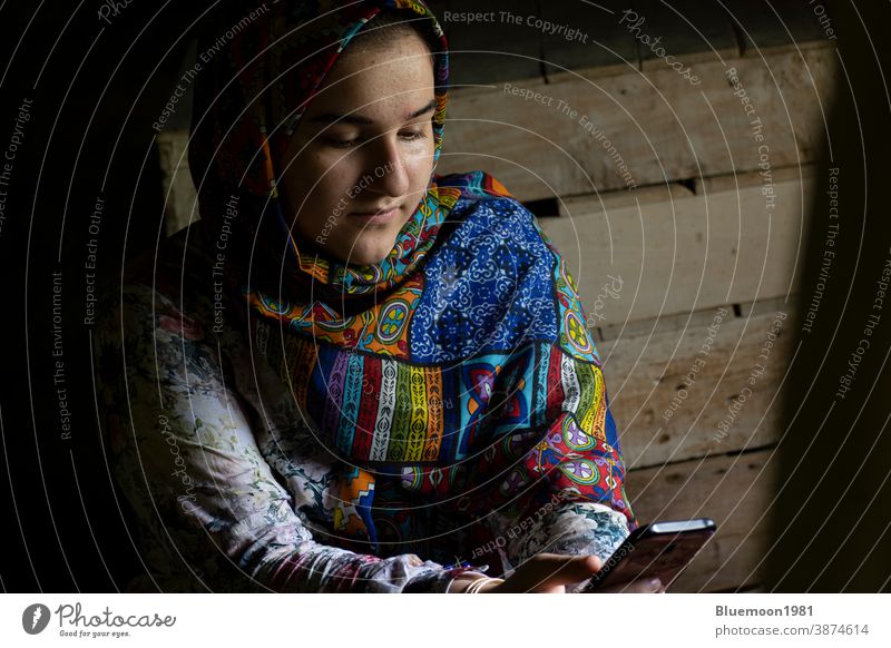 Porträt eines attraktiven muslimischen Mädchens im Teenageralter, das mit einem Smartphone arbeitet weiß Denken hell lässig Menschen Kaukasier niedlich Kleid