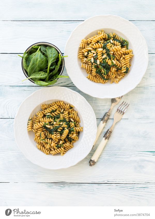 Vollkornnudeln mit Spinat und Pinienkernen Spätzle Lebensmittel Teller Tisch Holz Speise Veganer Vegetarier Blätter Italienisch Baby Mahlzeit rustikal organisch