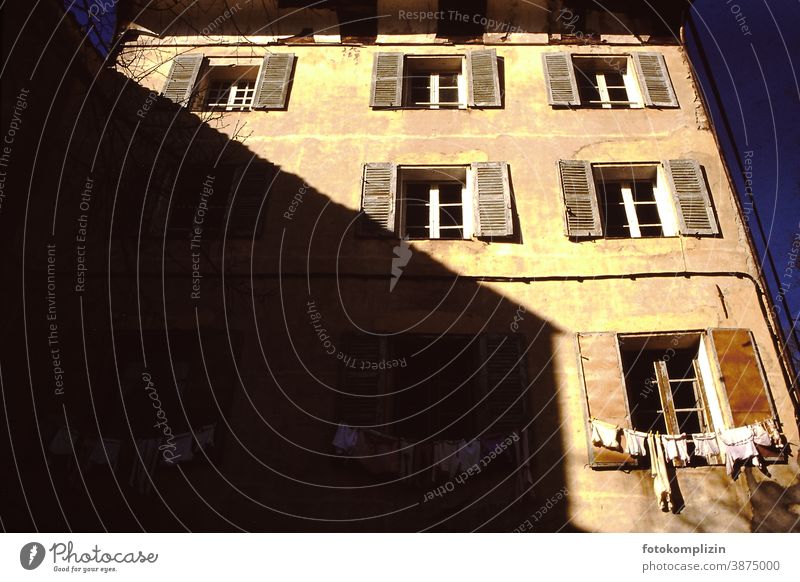 französische Altbaufassade mit Wäscheleine vor dem Fenster Fassade bauwesen architektur alt Haus Gebäude babywäsche Schatten hausschatten Frankreich südländisch