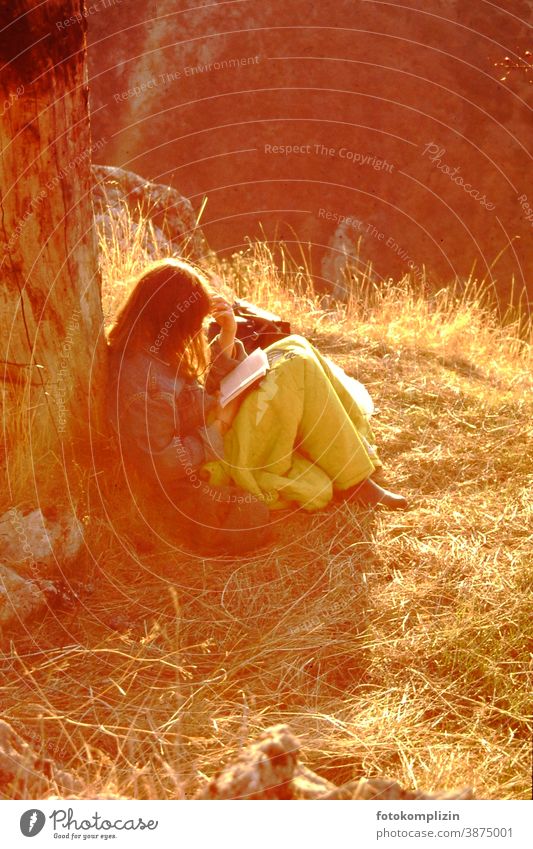junge Frau, im Sonnenlicht an einen Stamm gelehnt, liest versunken in einem Buch Lesepause lesen Natur feminin Kälte Pause wiederherstellen einsam Ruhe