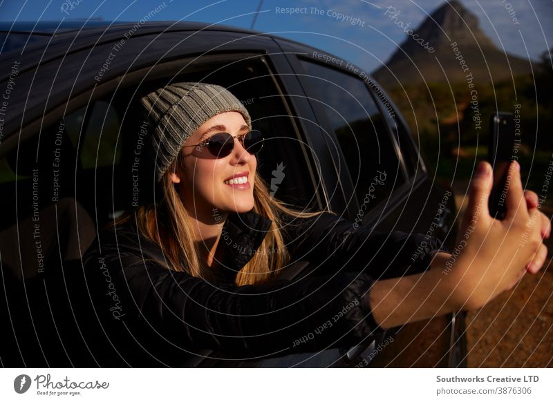 Junge Frau auf Autoreise Urlaub Fotografieren aus dem Fenster eines Mietwagens am Mobiltelefon Junge Frauen Feiertag PKW fahren Fahrer Autovermietung Reisen