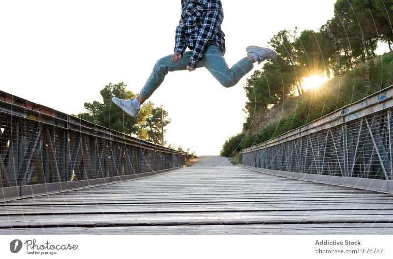 Energetische Hipster Mann springt über Holzbrücke springen hoch Brücke Energie Spaß haben Sprung aktiv Fliege männlich Steg Weg Fußweg Freiheit genießen