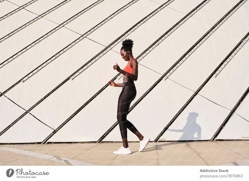 Schwarze Sportlerin auf der Straße an einem sonnigen Tag Athlet Großstadt Frau Lächeln schlank passen heiter Tanzen ethnisch schwarz Afroamerikaner