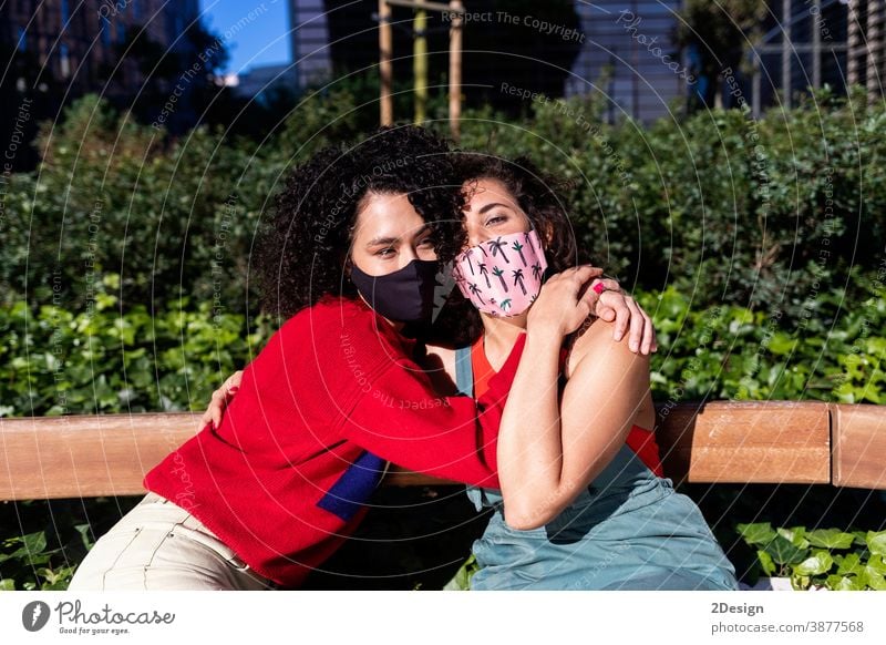 Lesbisches Paar mit Sonnenbrille, das sich auf einer Parkbank umarmt und entspannt Frau lesbisch Bonden Person Homosexualität Liebe Lifestyle Umarmung