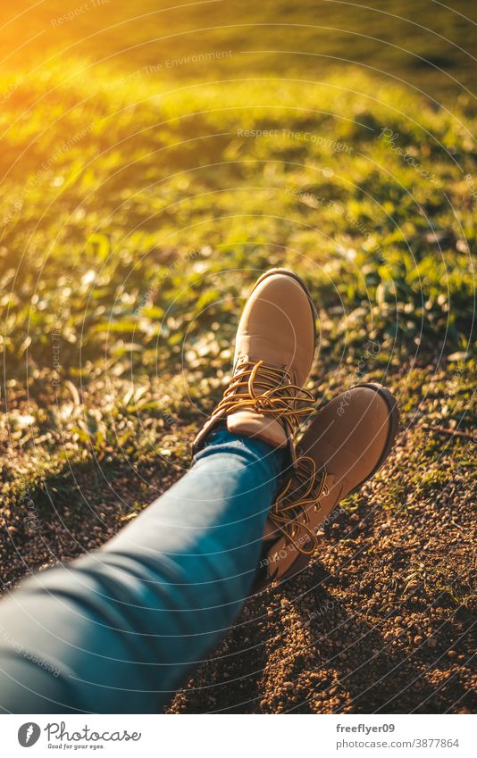Detail einiger Füße beim Entspannen Stiefel entspannend Frau Gras Textfreiraum Fuß Erholung Sonnenuntergang wandern Tourismus Tourist unkenntlich