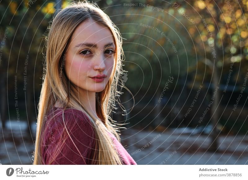 Langhaarige junge Frau schaut in die Kamera im Park lange Haare blond selbstbewusst modern Herbst Porträt natürlich Teenager Stil tausendjährig Behaarung
