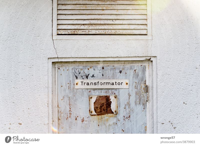 Ein Schild mit der Bezeichnung Transformator prangt an einer alten verwitterten Stahltür einer aufgegeben Trafostation altes Schild Schilder & Markierungen