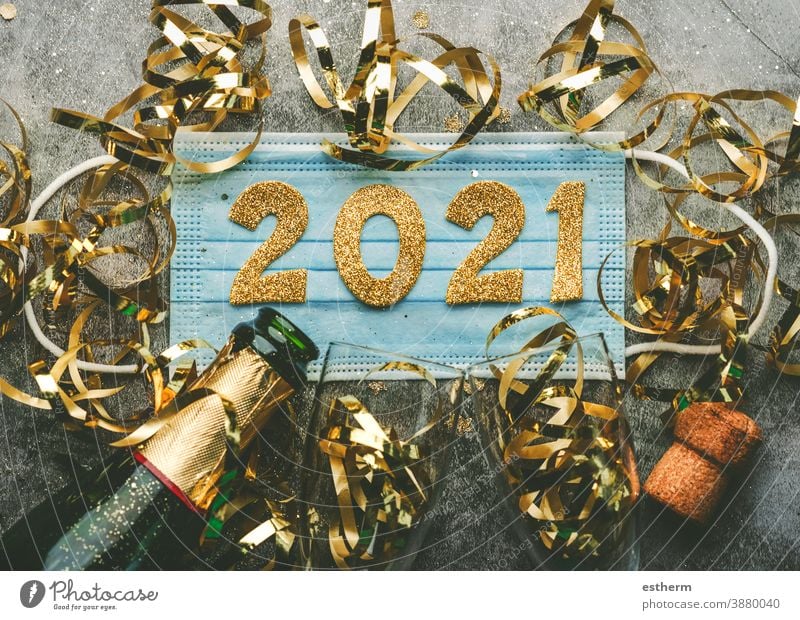 Hintergrund zum Konzept der Silvesterfeier: Medizinische Maske mit den Zahlen 2021 und Champagnerflasche mit Gläsern, Covid-19 Neujahrskonzept Weihnachten