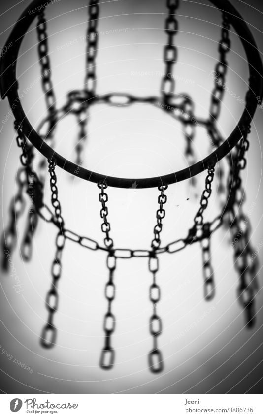 Basketballkorb in schwarzweiß vor hellem Hintergrund | Gestell und Ketten aus Metall Basketballplatz Kettenglied Korb Himmel Ballsport Sport Spielen