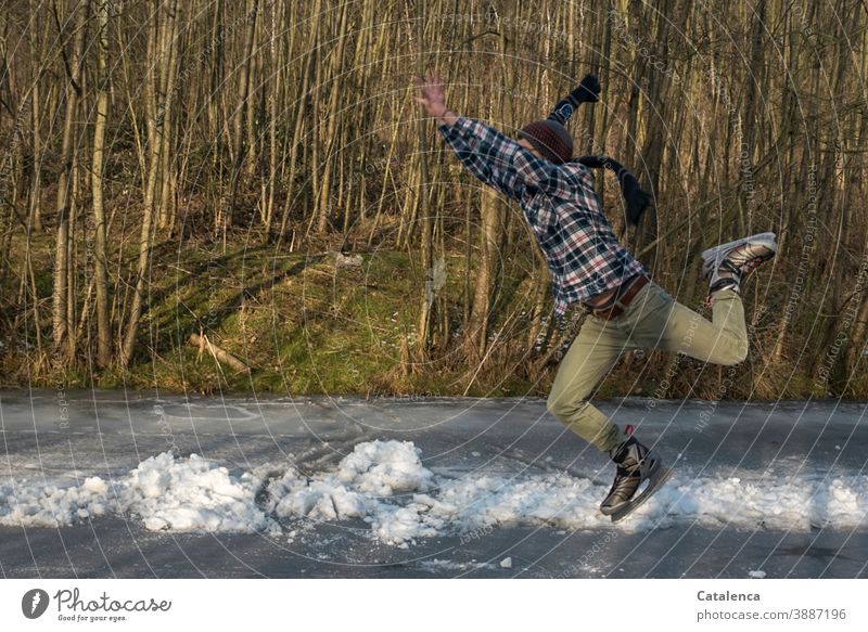 Ab ins Wochenende , junger Mann beim Eislaufen springen Eislaufschuhe Spass Winter Schal Kälte und Frost schnell Freude zugefroren Bäume See sportlich Grau Grün