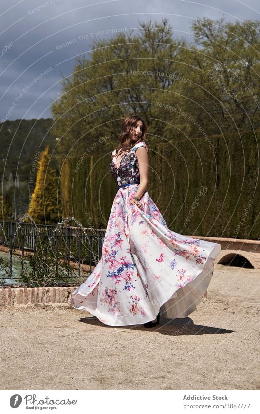 Elegante Frau dreht sich im Kleid im Park um sich im Kreise drehen sich umdrehen Anmut elegant langes Kleid maxi Garten sonnig feminin sorgenfrei Freiheit