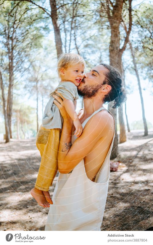 Glücklicher Vater küsst süßes Kind im Wald Kuss Wange Liebe niedlich Angebot Zusammensein Wochenende ethnisch rassenübergreifend vielfältig Elternschaft