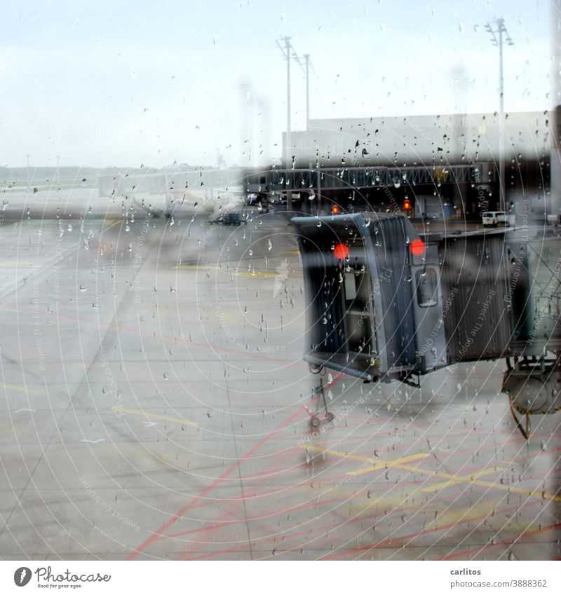 Ab in den Süden| Regentropfen an der Scheibe - Fluggastbrücke in Sicht, aber kein Flugzeug Flughafen Abflug Ankunft Wartezone Wartebereich Fenster grau