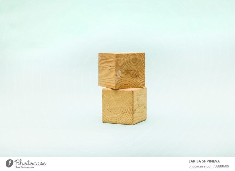 Abstrakter pastellfarbener Hintergrund mit zwei geometrischen Holzformen. Form einer Holzwürfelschachtel für Öko-Produkt. Leere Vitrine im Miniaturstil. Podium