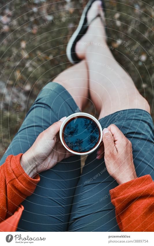 Nahaufnahme einer Frau, die im Freien sitzt und eine Tasse mit Kaffee hält oben Wanderer Ausflug Fernweh Erkundung Lifestyle Picknick Lager Freiheit Urlaub