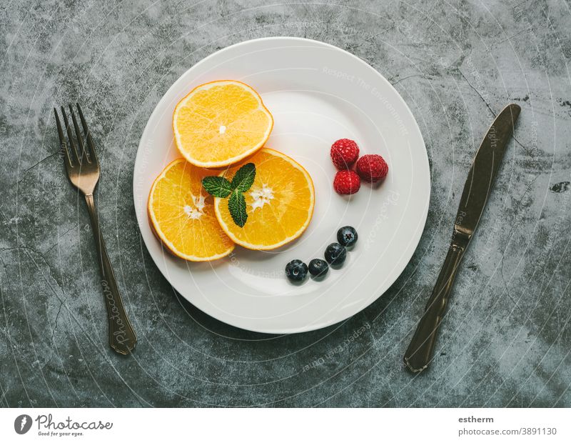 Gesundes Dessert.weißer Teller mit Orangenscheiben,Himbeeren,Heidelbeeren und altem Besteck gesundes Frühstück gesundes Dessert Fitness Gesundheit Frucht Natur