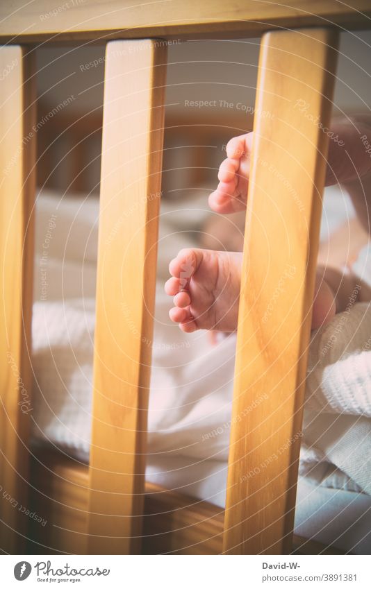 kleine Füße eines Babys am Gitterbett Kleinkind niedlich Babyfüße Zehen schlafen Kindheit zart Bett