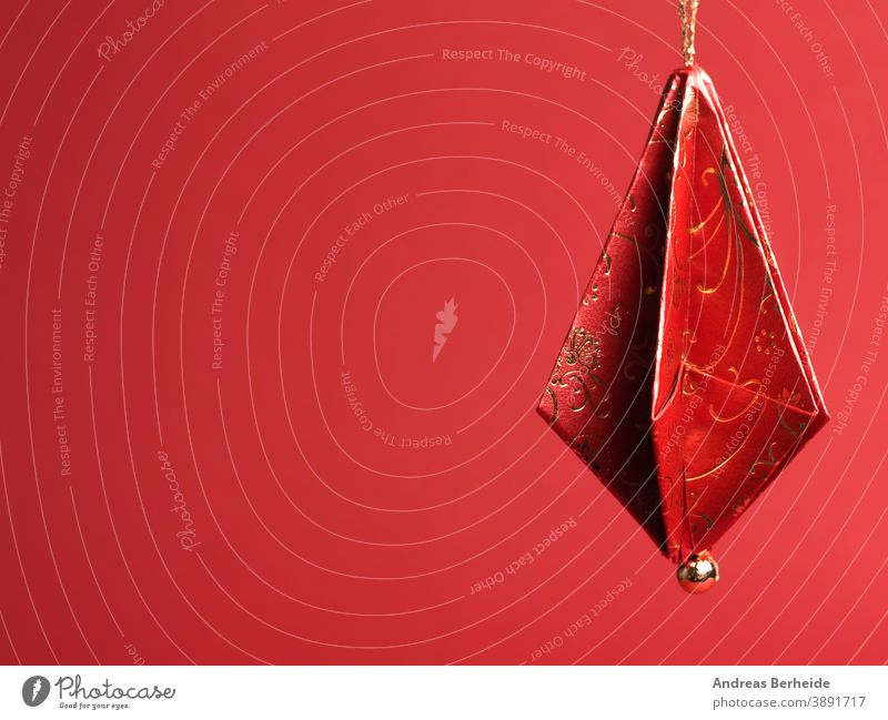 Christbaumschmuck aus schönem rot-goldenen Dekorpapier vor rotem Hintergrund gefaltet Origami Papier Weihnachten selbstgemacht handgefertigt