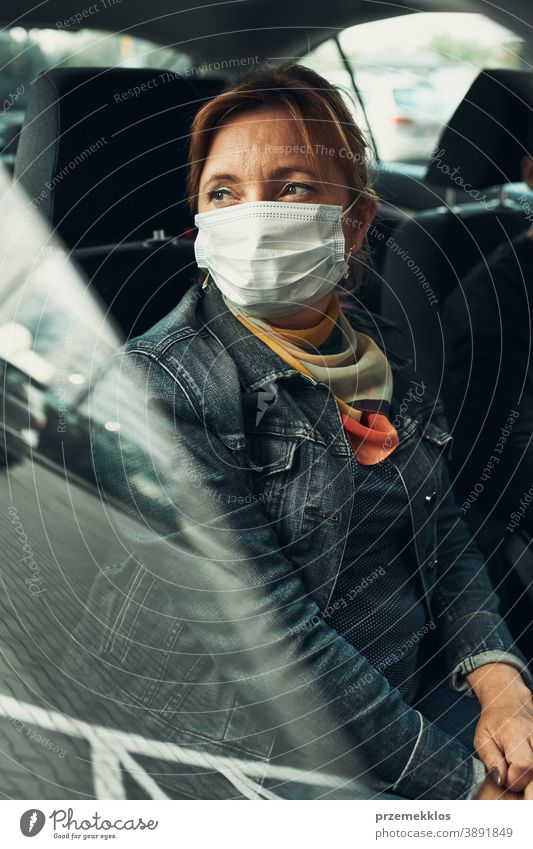 Frau sitzt in einem Auto und trägt die Gesichtsmaske, um eine Virusinfektion zu vermeiden Kaukasier covid-19 Lifestyle Mundschutz Ausbruch Pandemie Schutz