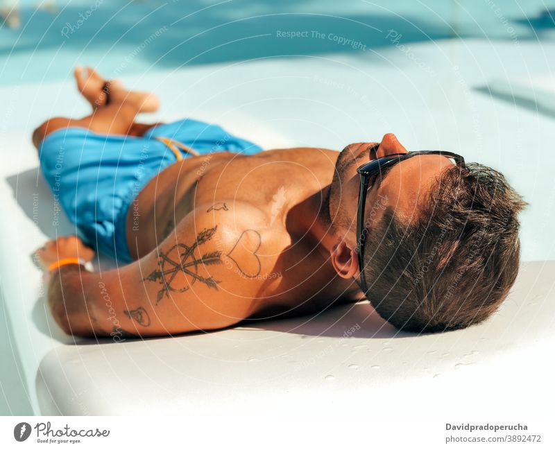 Mann entspannt auf Liegestuhl am Pool Sonnenbad sich[Akk] entspannen Reisender Beckenrand Lügen Urlaub Resort ruhen sorgenfrei Sommer reisen Hotel Kälte