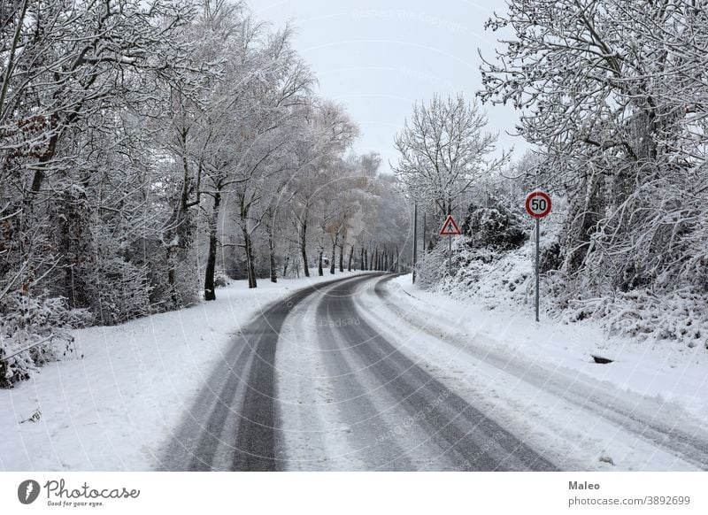 Gefährliche Kurve auf glatter, schneebedeckter Straße im Winter Schnee verschneite gefährlich kalt Wald rutschig reisen drehen. weiß Weg Asphalt Natur