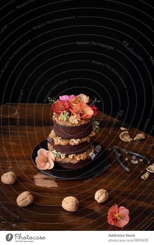 Leckerer Schokoladenkuchen mit Walnüssen am Tisch serviert Kuchen Walnussholz Blume dienen rustikal Dessert süß Lebensmittel festlich geschnitten Gebäck