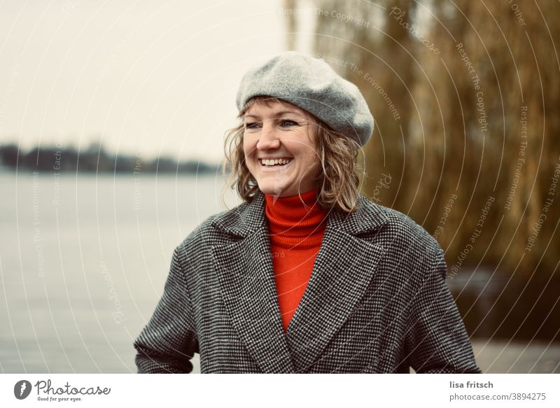 LACHEN - HERBST - MÜTZE - FRÖHLICH Frau 30 Jahre alt blond Locken Haare & Frisuren Baskenmütze Kopfbedeckung Fröhlichkeit Zufriedenheit lachen glücklich Wasser